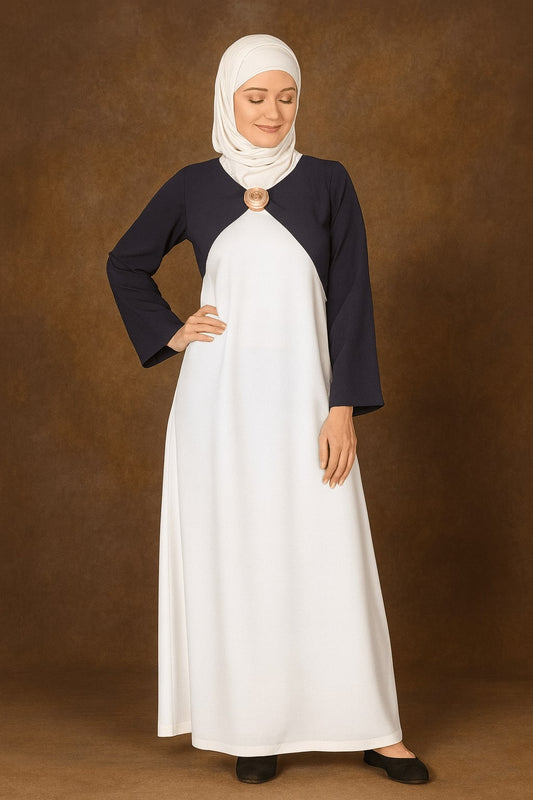 Woman wearing a white dress with navy sleeves against a brown background