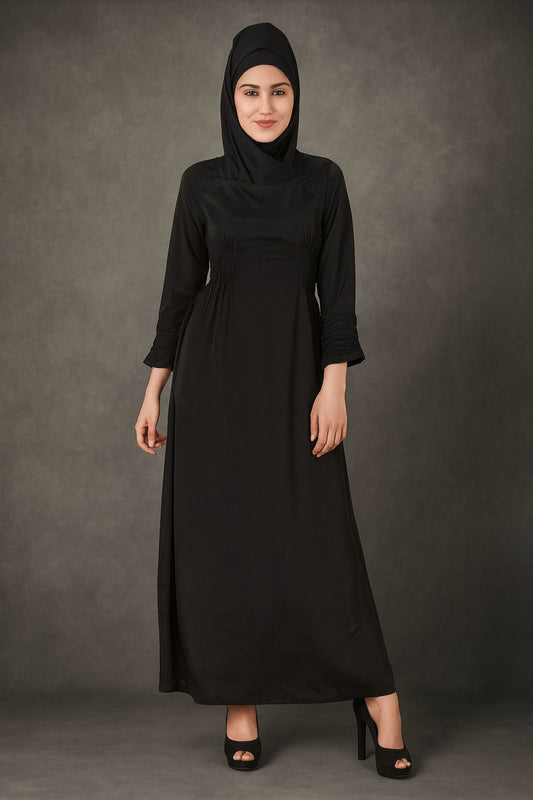 Woman wearing a black abaya against a gray background