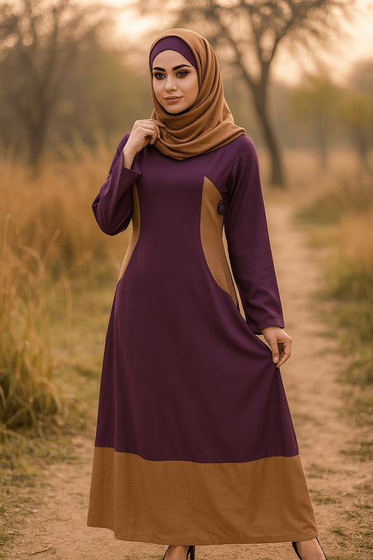 Woman wearing a purple and brown dress with hijab standing in a natural setting.