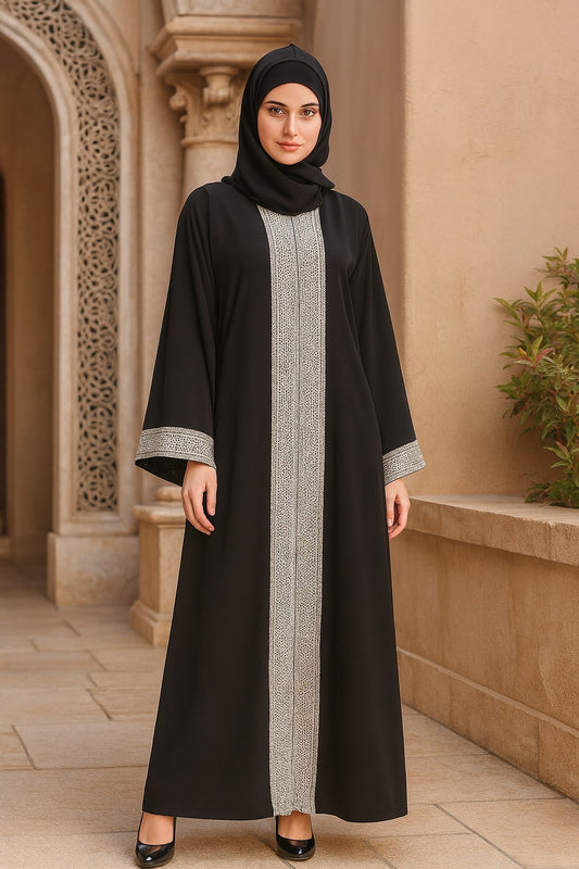 Woman wearing a black abaya with silver trim in an architectural setting