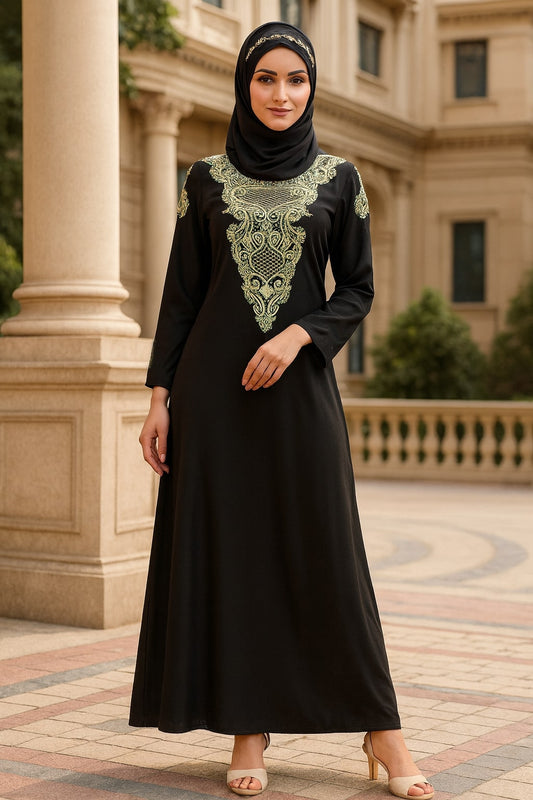 Woman wearing a black dress with green embroidery in front of a building.