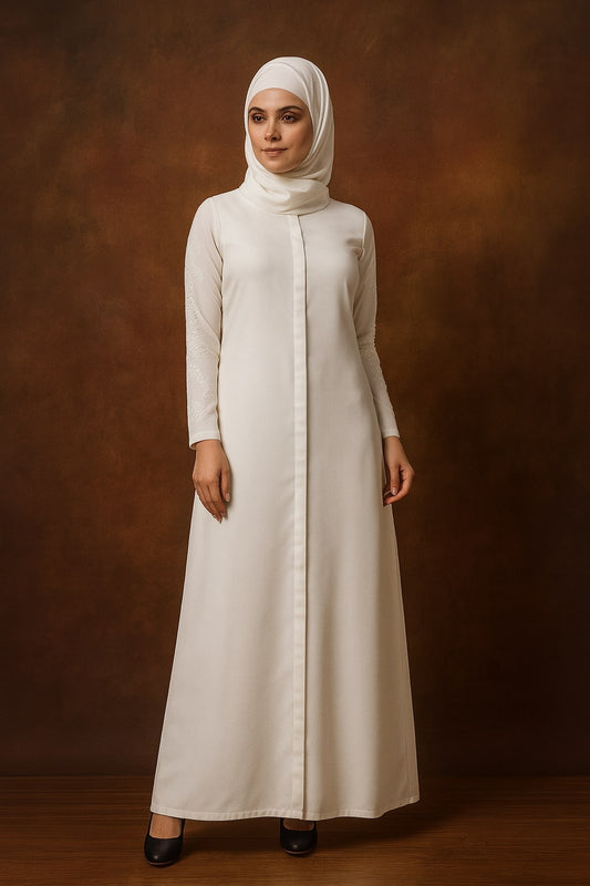 Woman wearing a long, light-colored dress with a hijab against a brown background