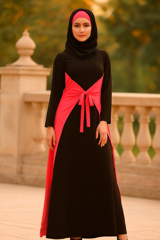 Woman wearing a black and pink dress with a hijab in an outdoor setting