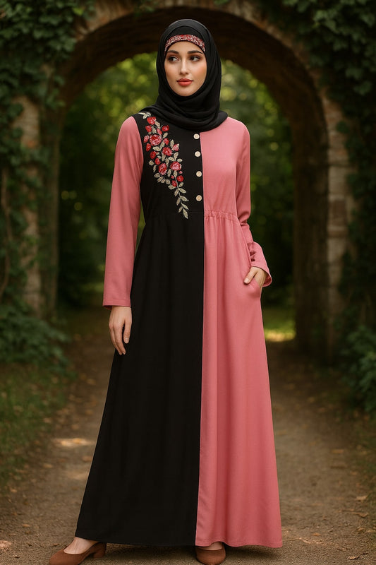 Woman wearing a black and pink dress with floral embroidery in an outdoor setting.