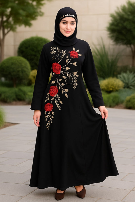 Woman wearing a black dress with red floral embroidery in an outdoor setting