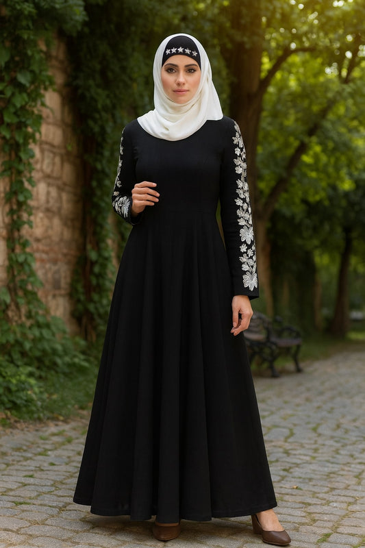 Woman wearing a black dress with white floral sleeves in an outdoor setting.
