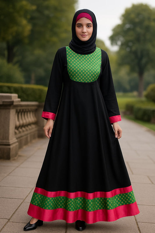 Woman wearing a black dress with green and pink accents in an outdoor setting