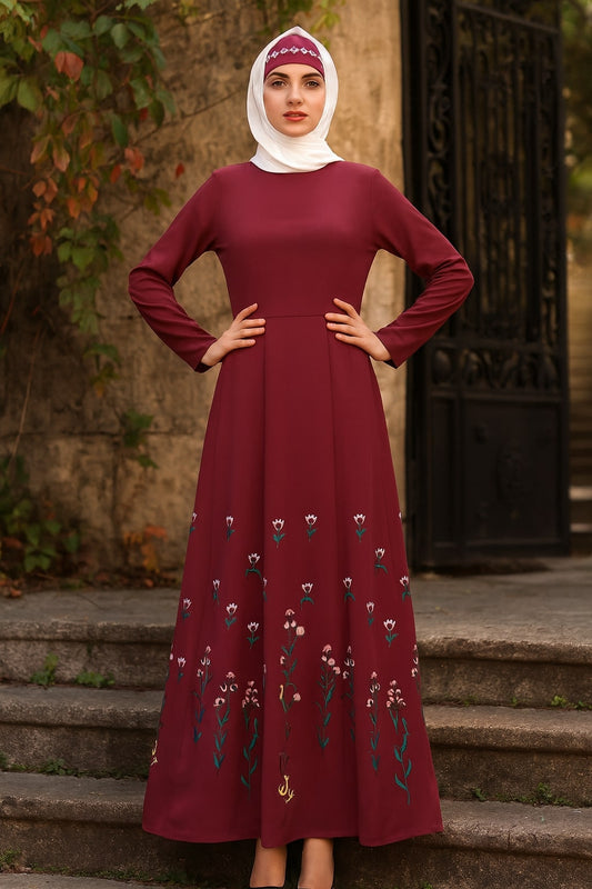 Woman wearing a burgundy dress with floral embroidery standing on steps.