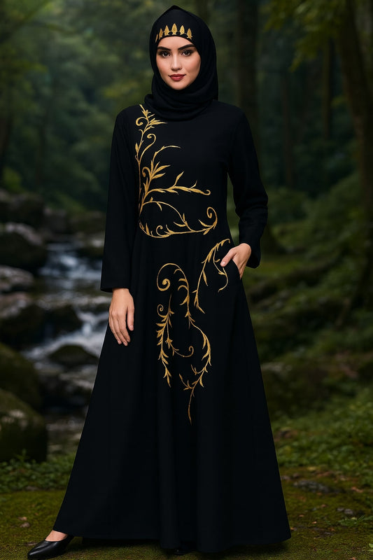 Woman wearing a black dress with gold embroidery in a forest setting