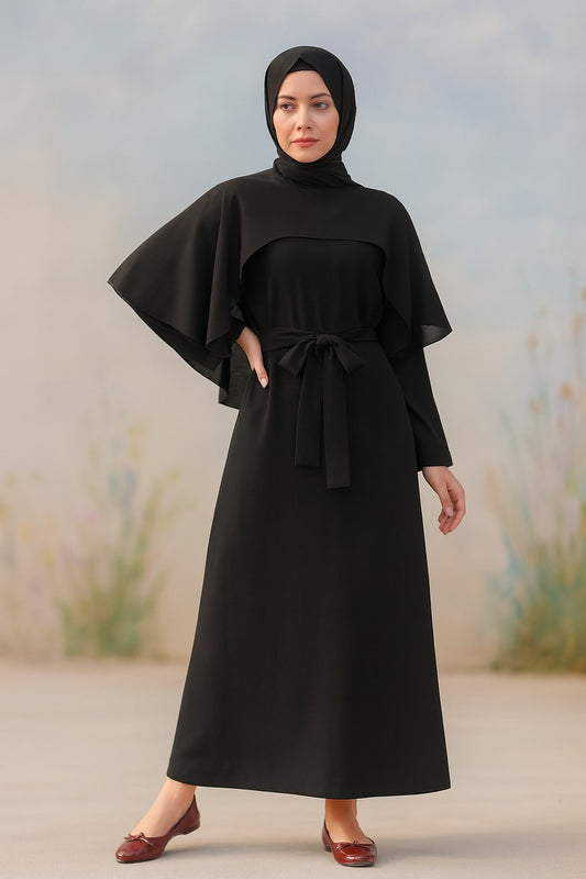 Woman wearing a black dress with cape and hijab against a blurred natural background