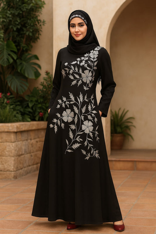 Woman wearing a black dress with floral embroidery in an outdoor setting