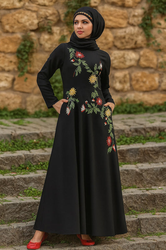 Woman wearing a black dress with floral embroidery standing on stone steps.