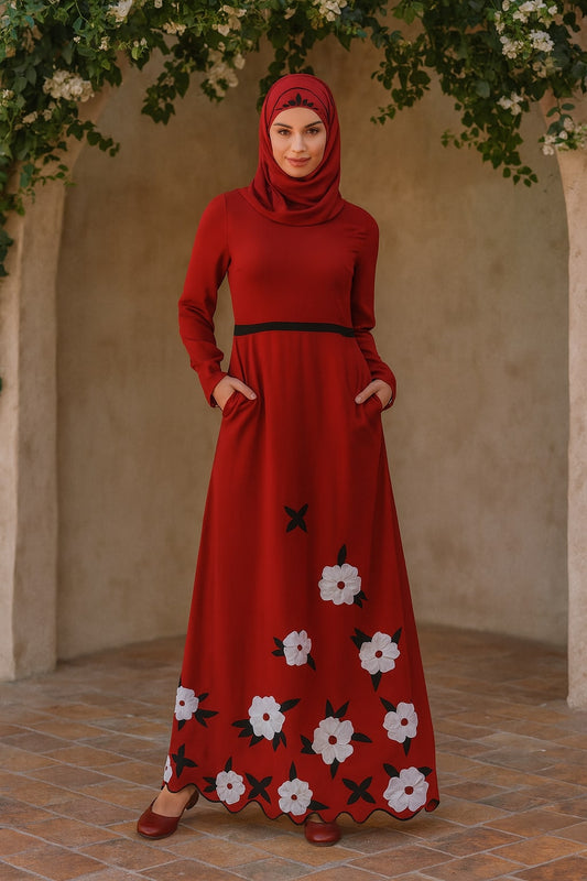 Woman wearing a red dress with floral patterns standing under a floral archway.
