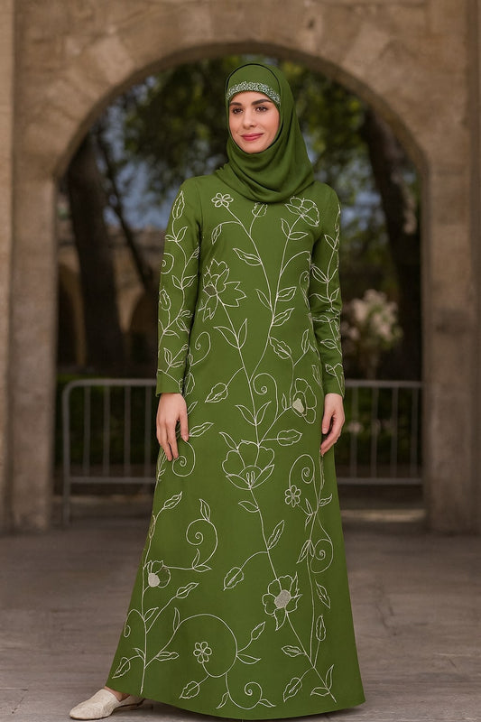 Woman wearing a green dress with floral patterns in front of a stone archway.