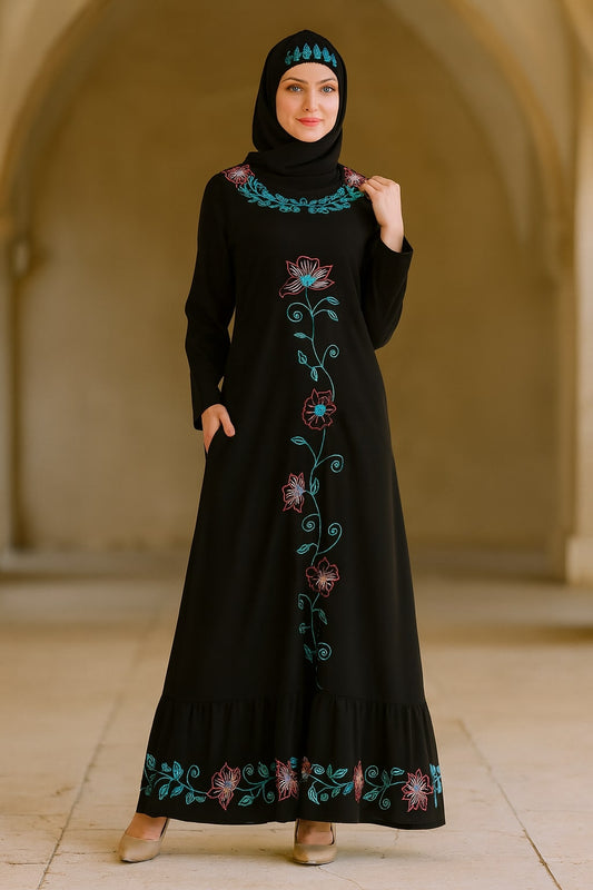 Woman wearing a black dress with floral embroidery in an indoor setting