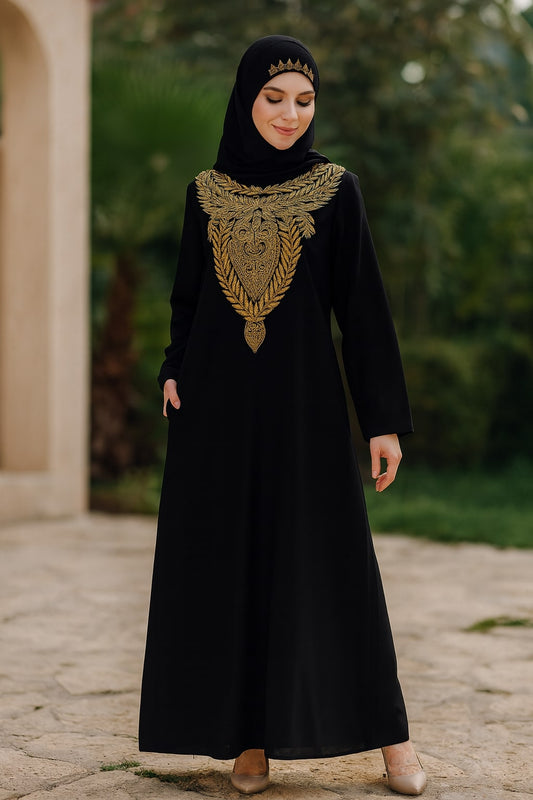 Woman wearing a black abaya with gold embroidery standing outdoors.