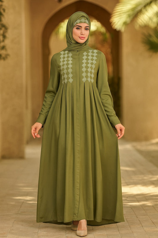 Woman wearing a green dress with a matching hijab in an outdoor setting.