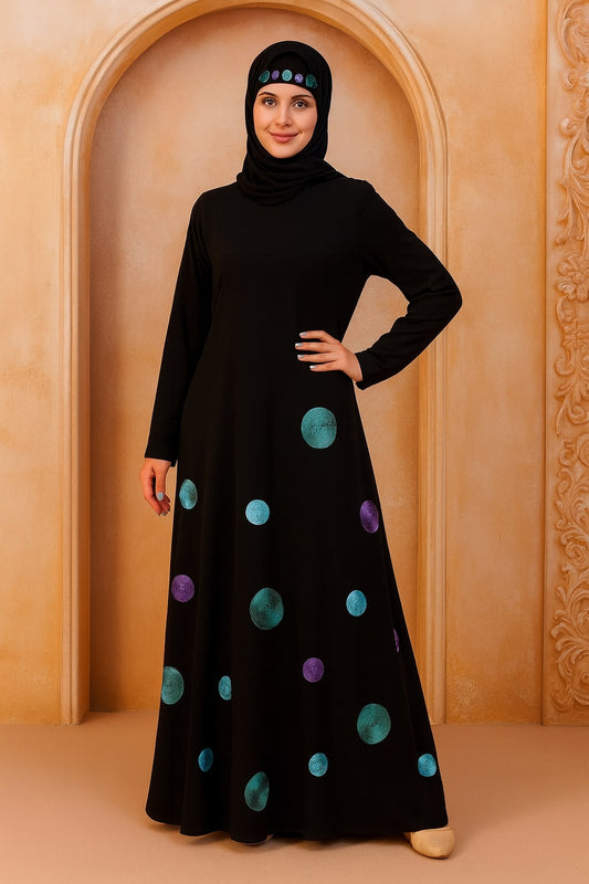 Woman wearing a black dress with colorful polka dots against a beige wall.