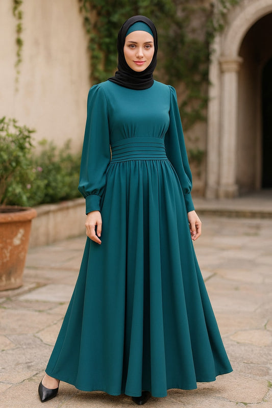 Woman wearing a teal dress and black hijab standing outdoors.