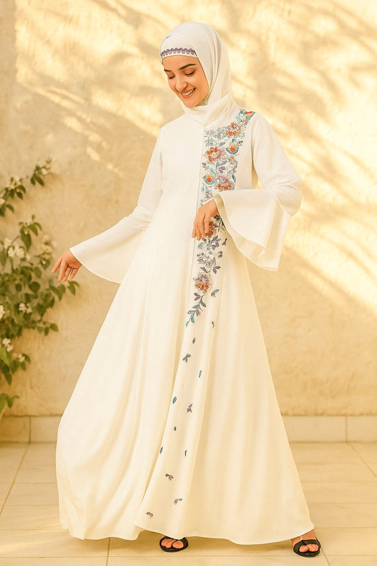 Woman wearing a white dress with floral embroidery in a warm-toned indoor setting