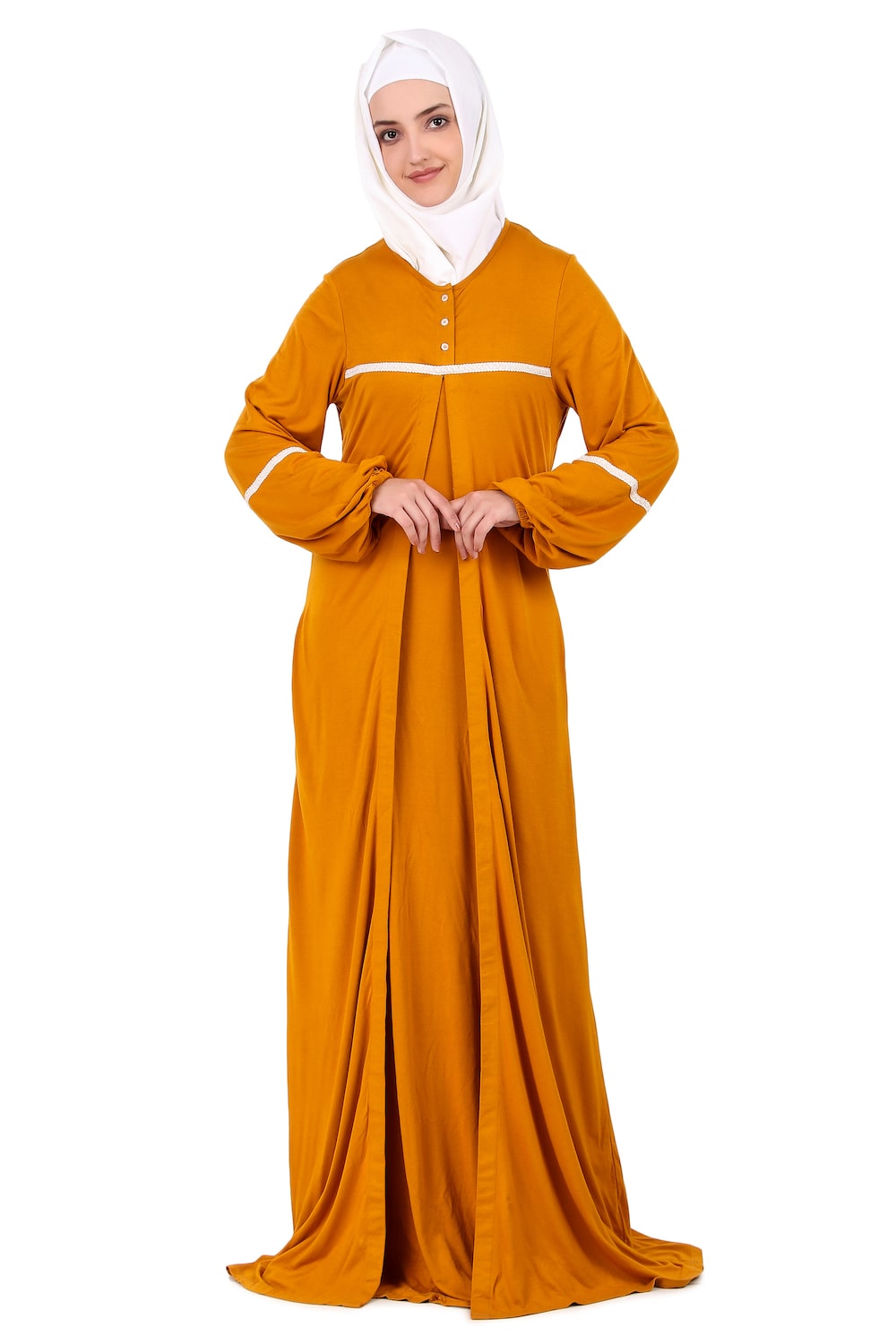 A woman wearing a mustard yellow jersey lace abaya with a round neck, button closure placket, lace embellishment at the waist, and straight sleeves with matching lace cuffs. She is also wearing a white headscarf.