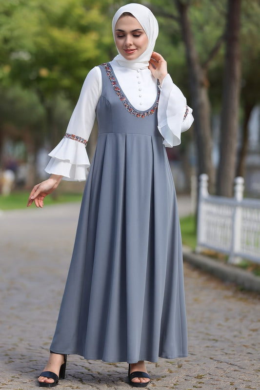 Woman wearing a gray dress with white blouse outdoors