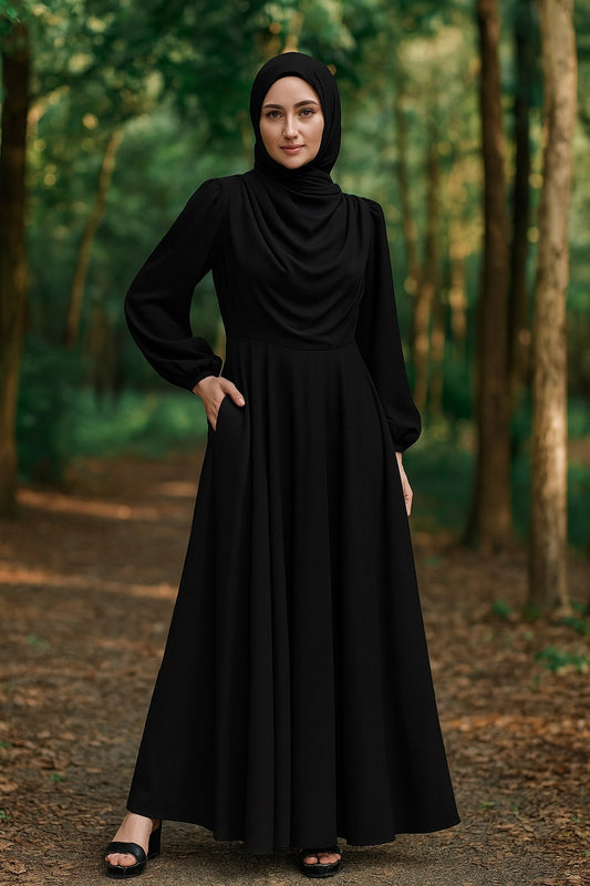 Woman wearing a black abaya in a forest setting