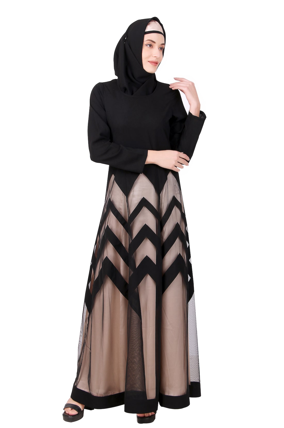 A woman wearing a black and gold zig zag patterned Nida & Net Abaya with a round neck and straight sleeves, without pockets. She is also wearing a matching square hijab.