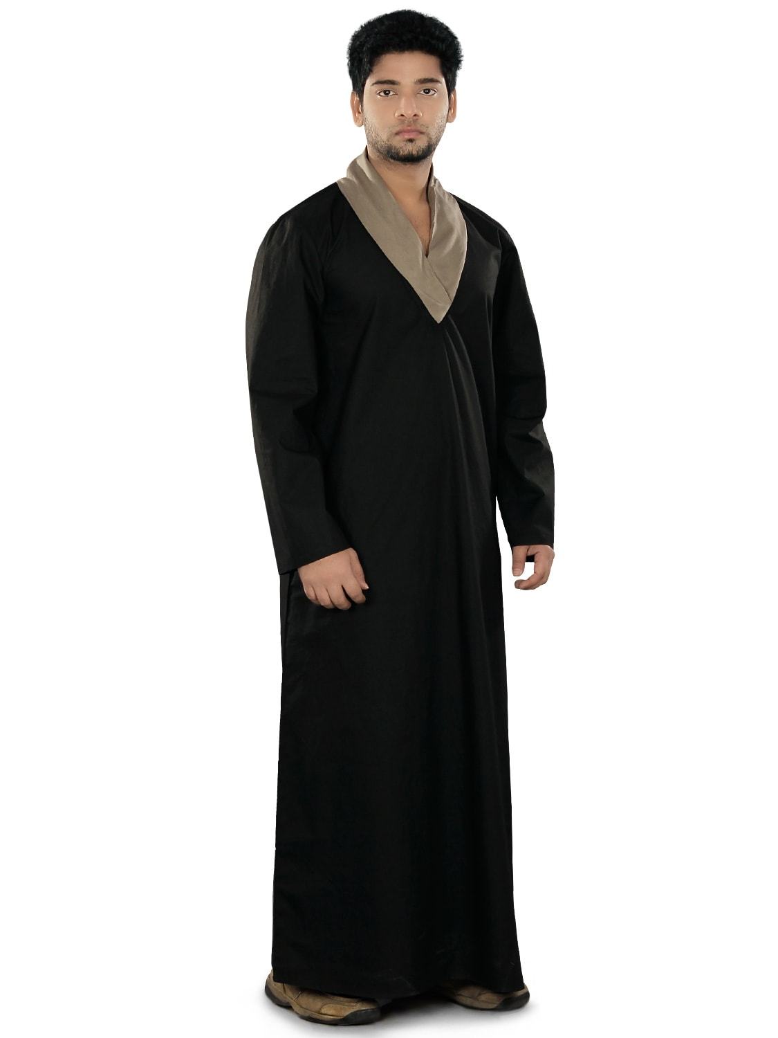 A man wearing a black galabiyya with a shawl collar neck and straight sleeves, featuring utility pockets on the sides.