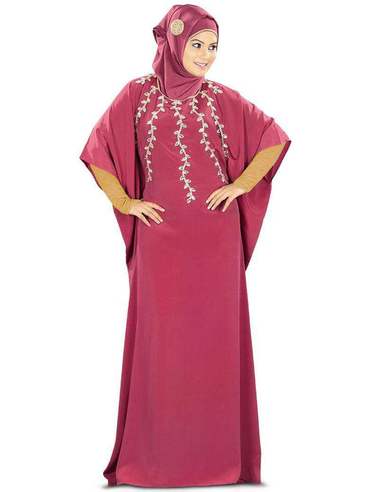 A model wearing a rose pink hand embroidered Kaftan with a round neckline and bead and stone embroidery detailing.