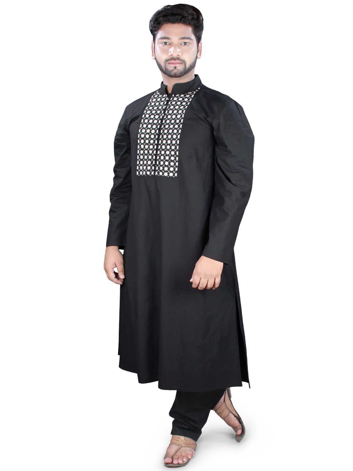 A person standing and posing in a black kurta pajama with embroidered neckline and side slits on the pants.