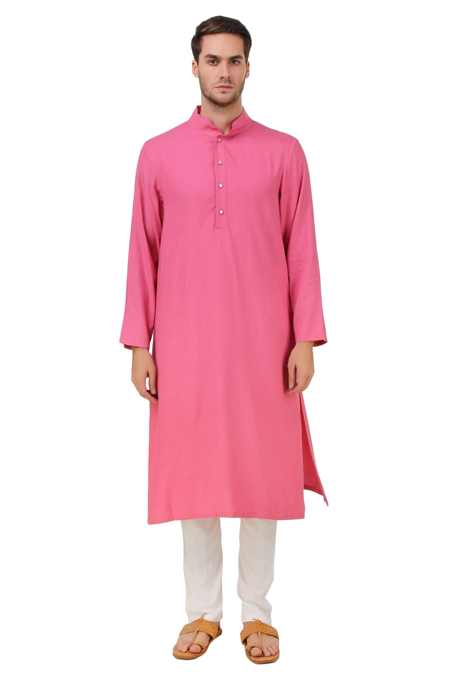 A person wearing a pink kurta pajama set with a mandarin collar and button opening placket, featuring straight sleeves and sides slits. The pants have a drawstring waist and are full length.