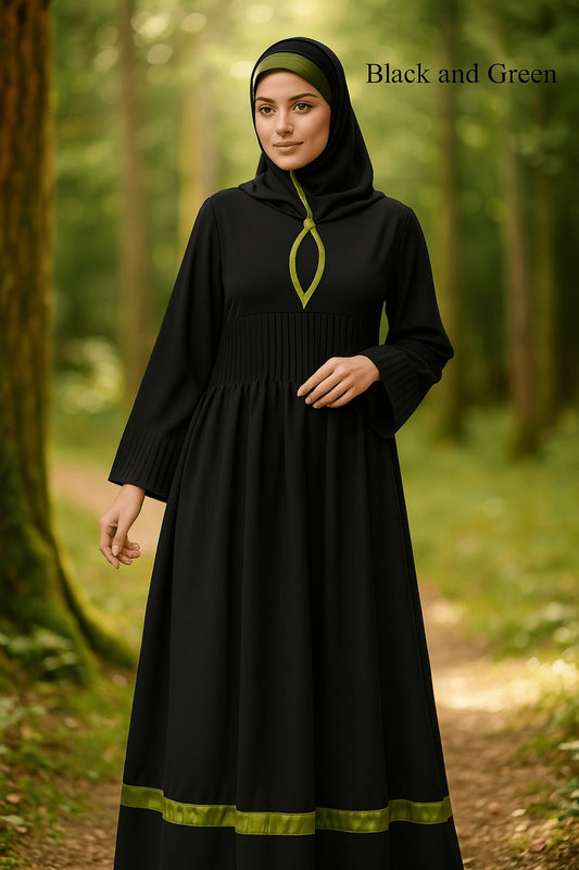 Woman wearing a black dress with green accents in a forest setting
