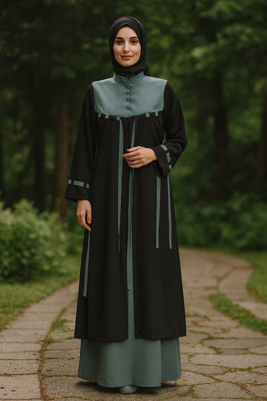 Woman wearing a black and green abaya in a forest setting