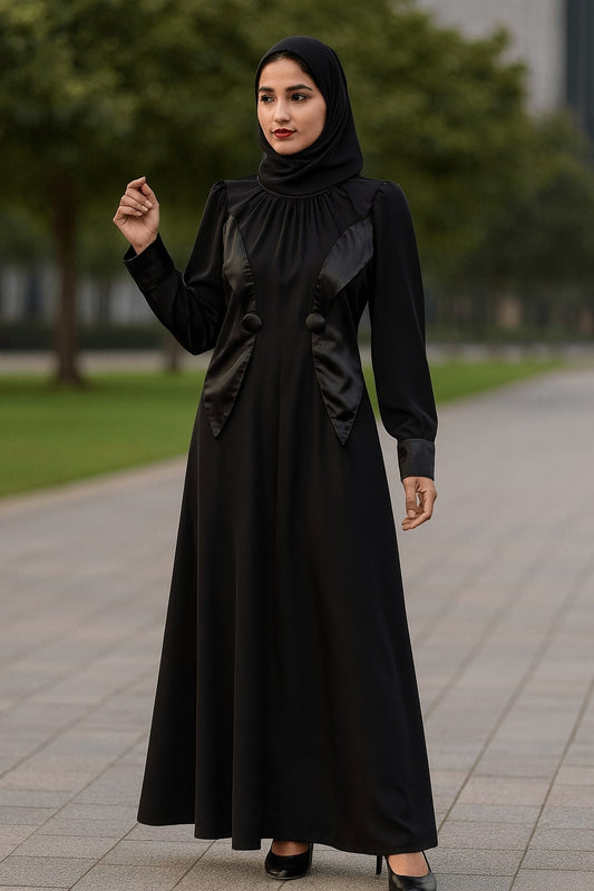 Woman wearing a black abaya standing on a sidewalk with greenery in the background