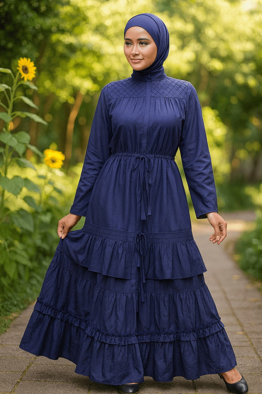 Woman wearing a navy blue dress with ruffled layers in a garden setting.