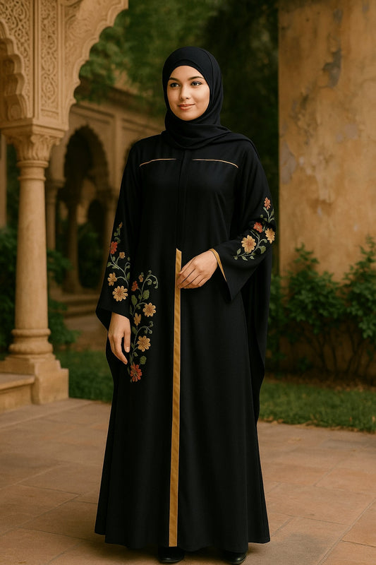 Woman in a black abaya with floral embroidery standing in an outdoor setting.