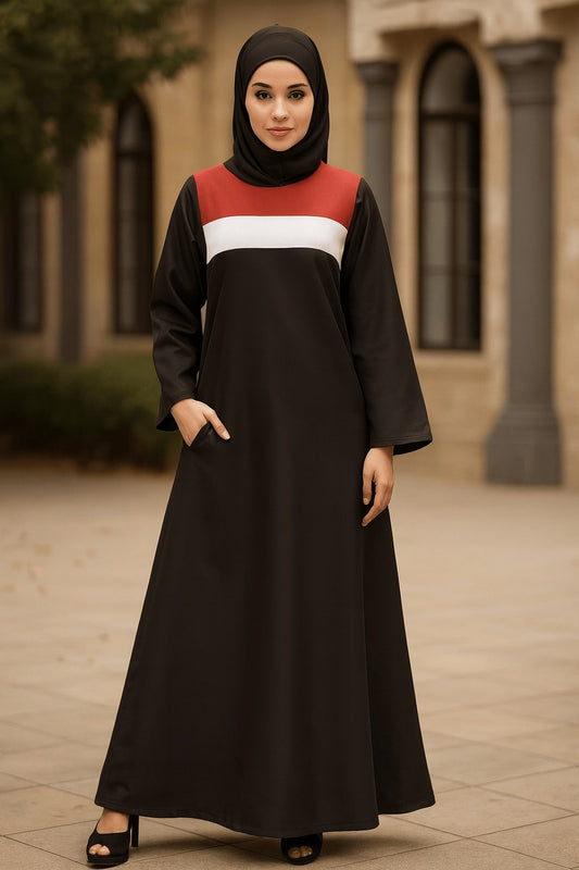 Woman wearing a black dress with red and white accents in an outdoor setting.