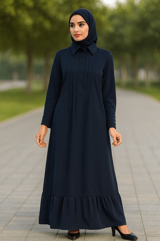 Woman wearing a black dress with a hijab standing on a pathway with greenery in the background