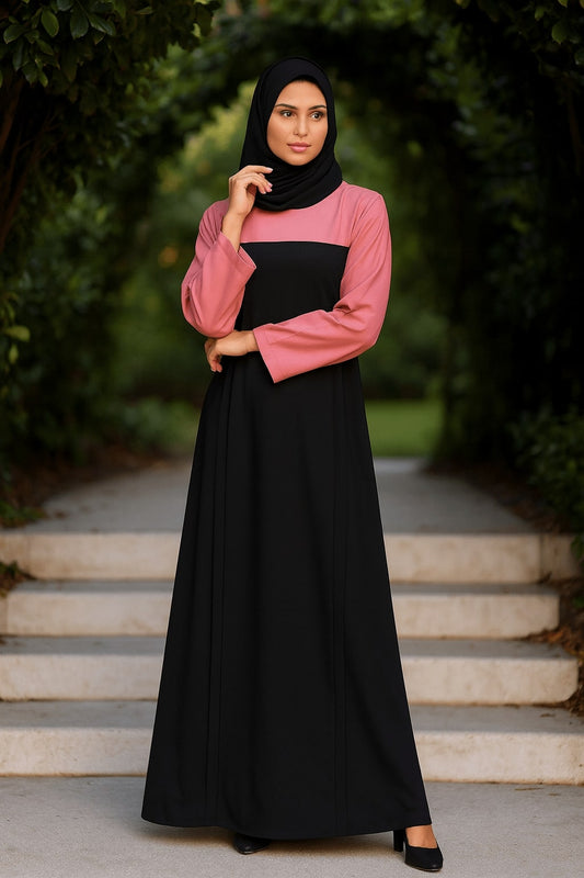 Woman wearing a black and pink dress with a hijab standing on steps outdoors.