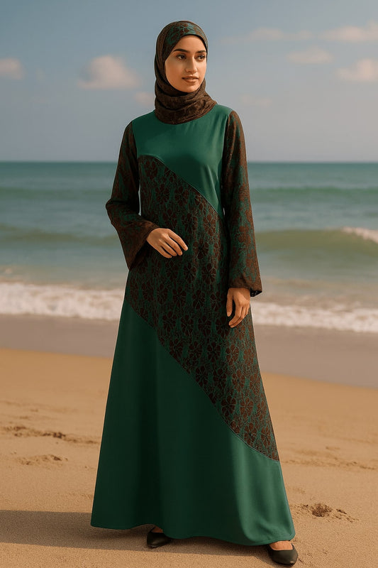 Woman in a green and brown dress standing on a beach with ocean waves in the background