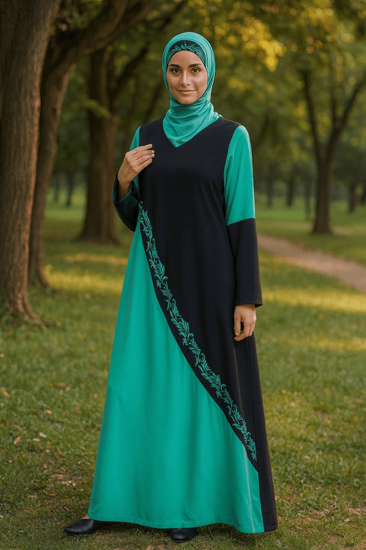 Woman wearing a black and teal dress with a hijab in a park setting
