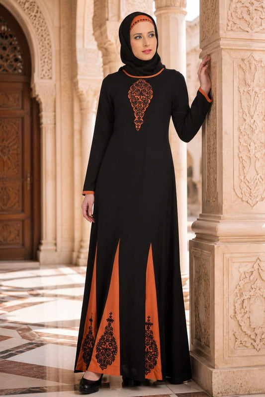 Woman wearing a black and orange dress with intricate patterns in an ornate architectural setting.