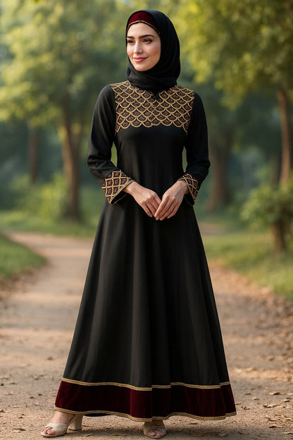 Woman wearing a black dress with gold embroidery standing on a path in a forest.