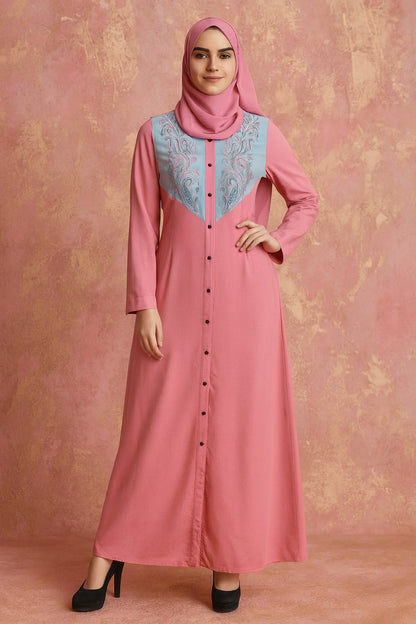 Woman wearing a pink dress with a patterned neckline against a pink background