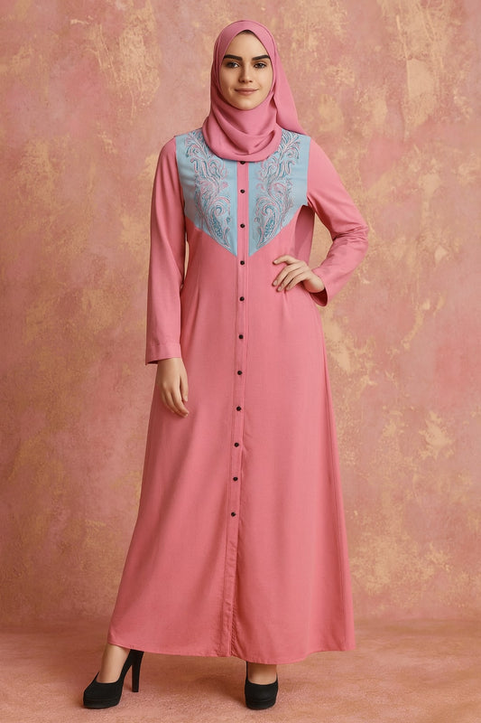 Woman wearing a pink dress with a patterned neckline against a pink background