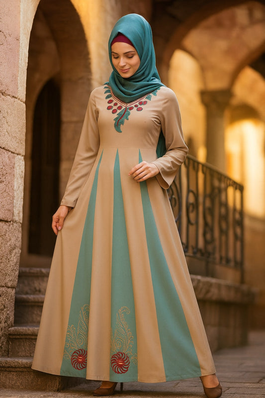 Woman wearing a long, beige dress with green accents in an outdoor setting.
