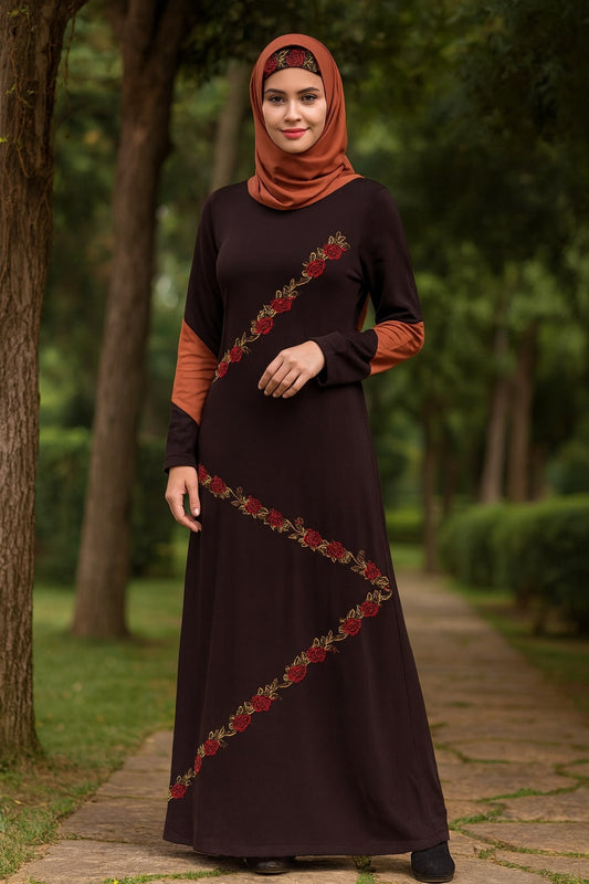 Woman wearing a dark brown dress with floral embroidery in an outdoor setting