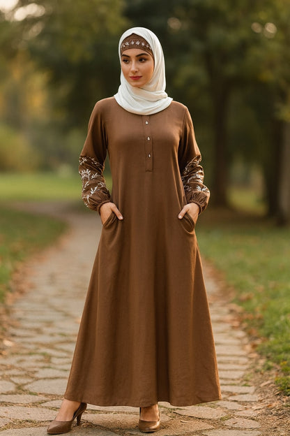 Woman wearing a brown dress with floral sleeves in a park setting