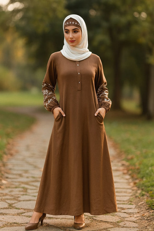 Woman wearing a brown dress with floral sleeves in a park setting